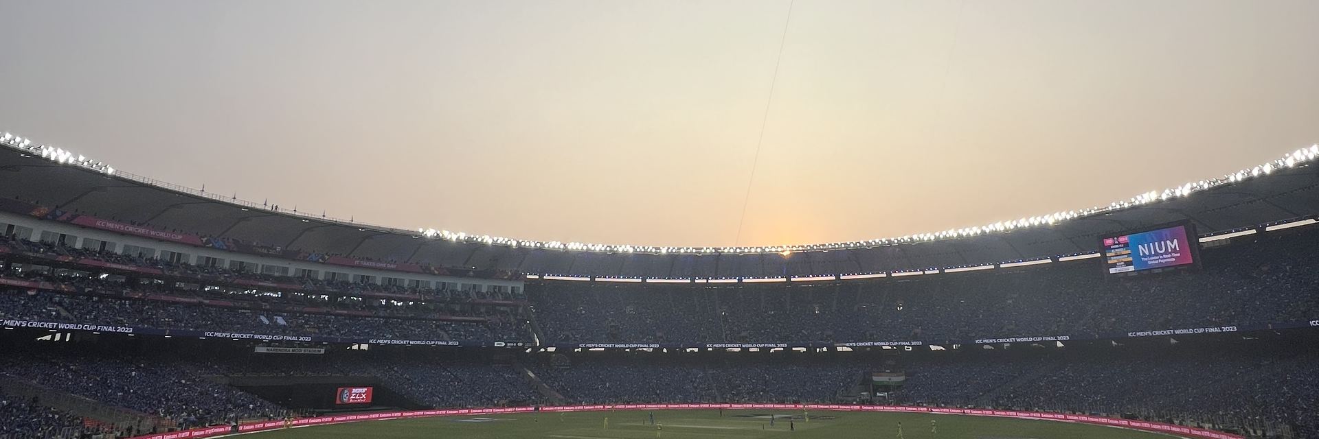 Floodlit cricket stadium in India at dusk